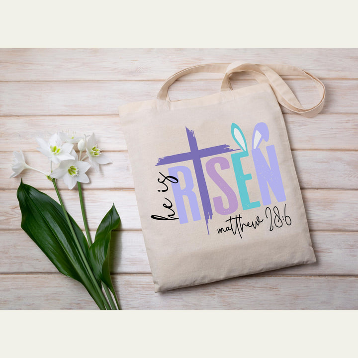 Easter He Is Risen DTF heat transfer with a bold purple cross and Matthew 28:6 verse, ready to press on spring tees.