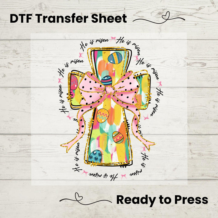 Colorful He Is Risen Cross DTF heat transfer with a pastel design, pink bow, and Easter eggs, ready to press on spring tees.