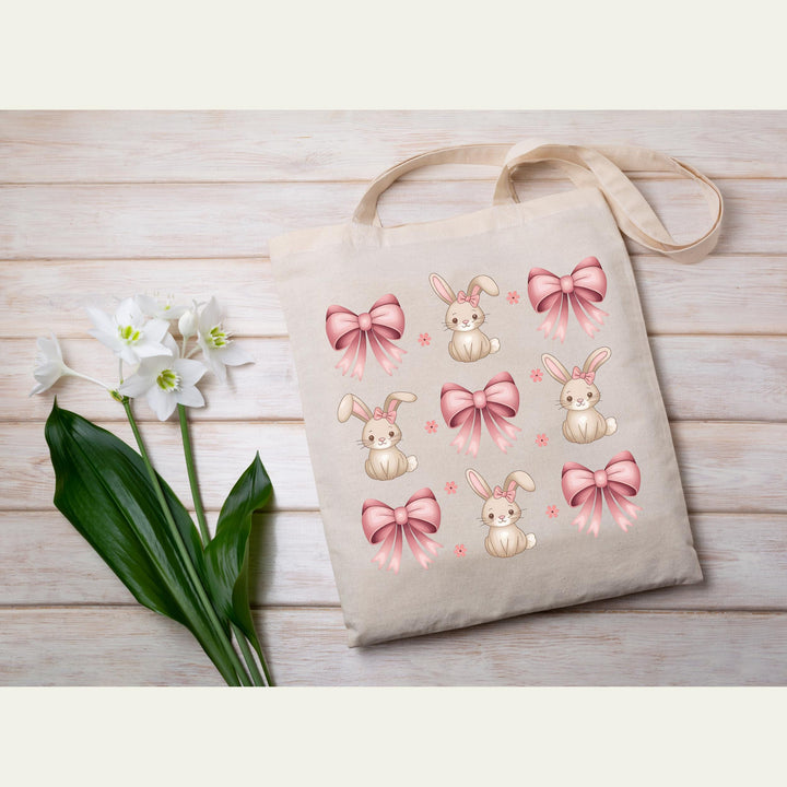 Adorable bunny design with soft pink satin bows, perfect for trendy Easter and spring outfits.