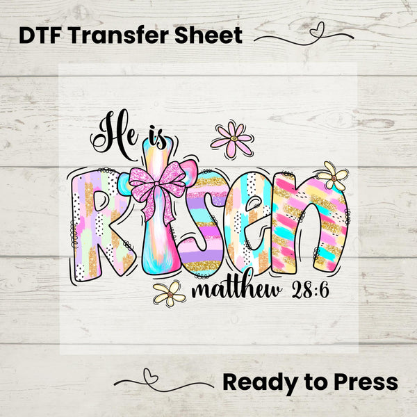 He Is Risen DTF heat transfer featuring a pastel cross, pink bow, and Matthew 28:6 scripture, ready to press on t-shirts