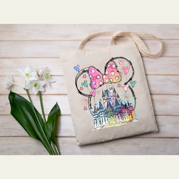 High-quality direct-to-film transfer with a fairytale castle, fireworks, and Mickey balloon accents in a Minnie ears shape.