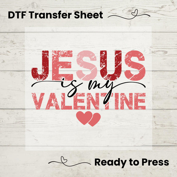A graphic design of text 'Jesus is my Valentine' with hearts, intended as a DTF transfer sheet for application on garments, displayed on a wooden background with the text 'Ready to Press'.
