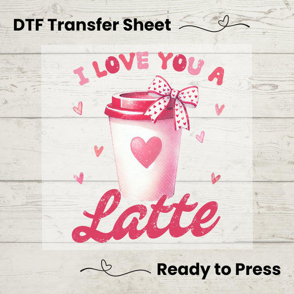 A graphic design of a coffee cup with the phrase 'I LOVE YOU A LATTE' printed on it, presented as a DTF (Direct to Film) transfer sheet, indicating it's ready to be pressed onto a garment.