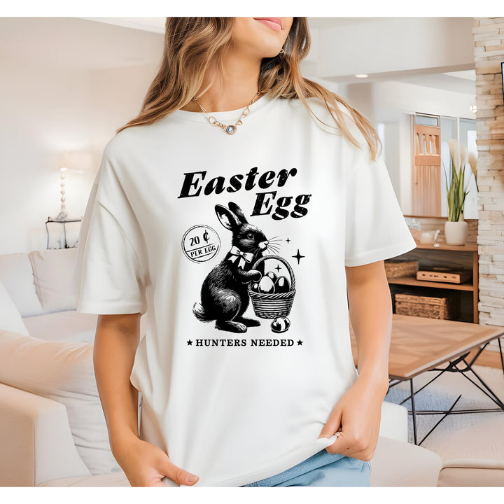 Retro-style black-and-white Easter Bunny holding an egg basket with "Easter Egg" text and "Hunters Needed" typography.