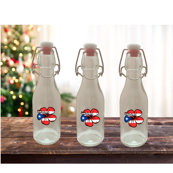 Three clear glass bottles with floral designs on a wooden surface with a festive background.